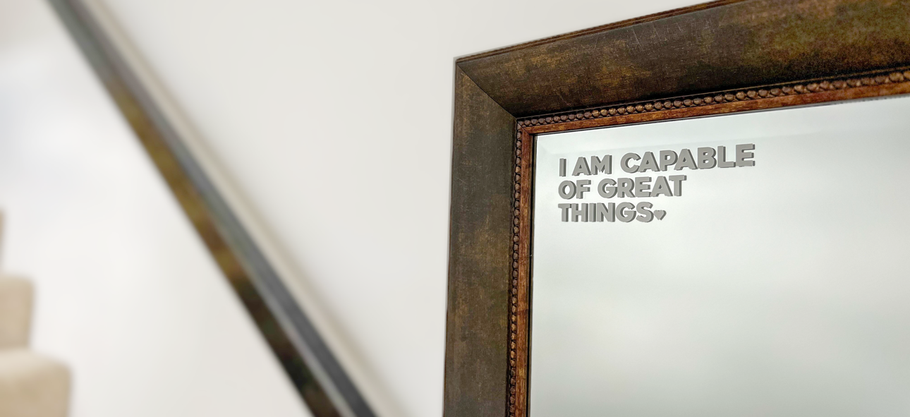 Decorative mirror with motivational quote 'I am capable of great things.' on a neutral background
